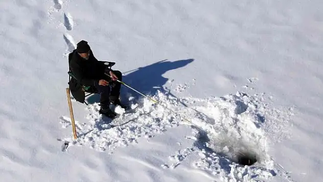 Baraj gölündeki 40 santimlik buzu kazma ile kırıp balık tutuyorlar