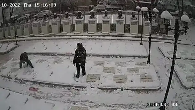 Çanakkale'de 2 çocuk karla kaplanan şehitlikteki mezar taşlarını temizledi