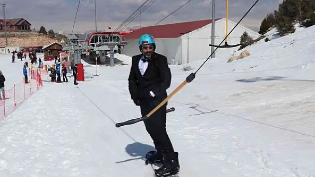 Kayak sezonunu takım elbiseyle snowboard yaparak uğurladılar