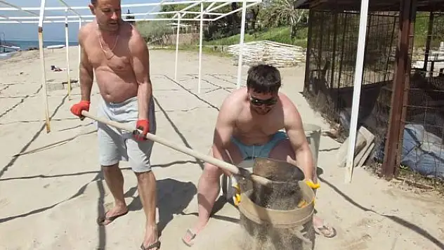 Örnek işletmeci, plaj kumlarını eliyor