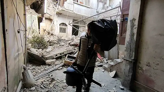 Suriyeli gencin harabeye dönen evinden eşya kurtarma çabası