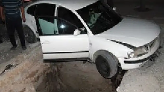Otomobille yoldaki çukurda asılı kaldı