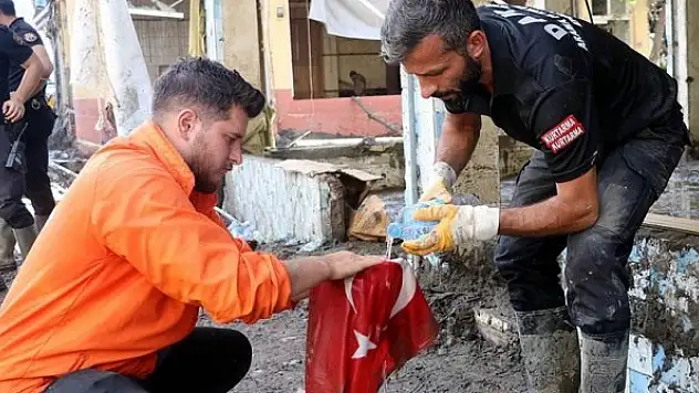 Selde çamurun altında kalan Türk bayrağını yıkayıp öperek yeniden astılar