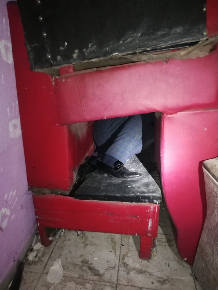 Ruhsatsız eğlence merkezini polis basınca, koltukların arasına gizlendiler
