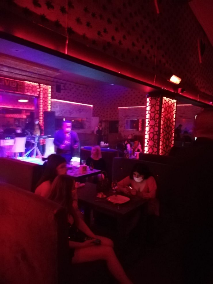 Ruhsatsız eğlence merkezini polis basınca, koltukların arasına gizlendiler