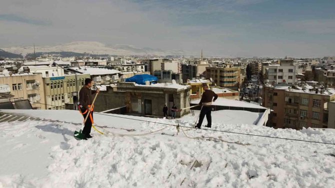 Vatandaşlar çatıda kar temizliyor
