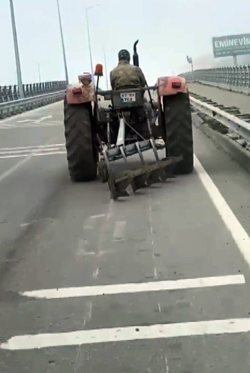 Traktör arkasındaki sabanla asfaltı çizerek karayolunda seyir etti