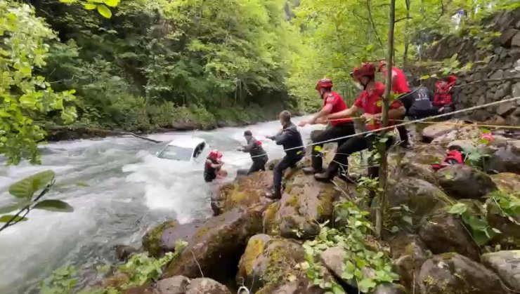 Dereye uçan otomobilin üzerine çıkıp kurtarılmayı beklediler