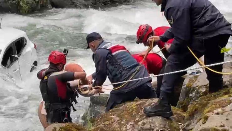 Dereye uçan otomobilin üzerine çıkıp kurtarılmayı beklediler