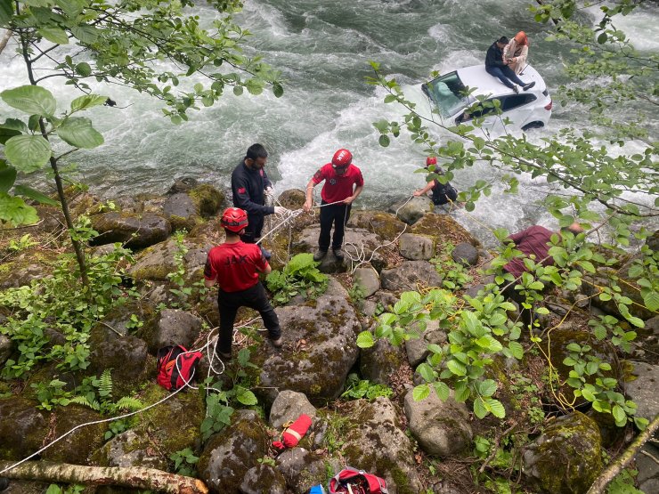 Dereye uçan otomobilin üzerine çıkıp kurtarılmayı beklediler