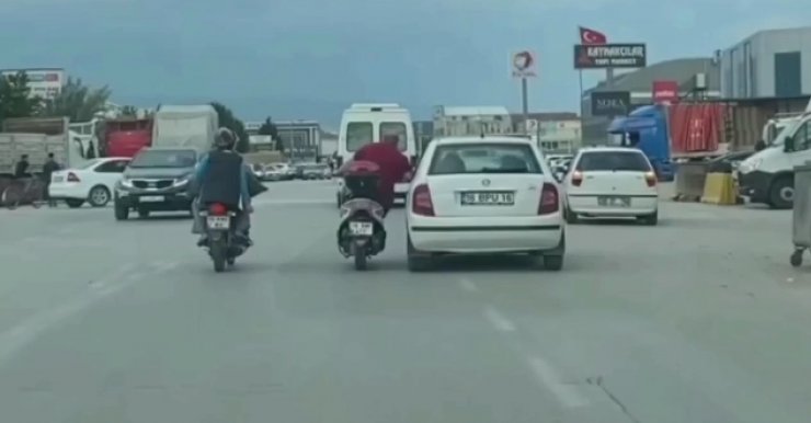 Otomobilin kapısına tutunarak sürücüyle sohbet etti