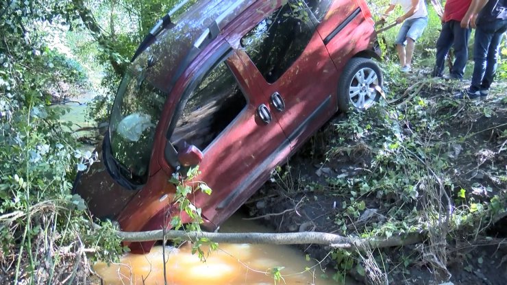 Dereye düşen otomobilden burunları bile kanamadan çıktılar