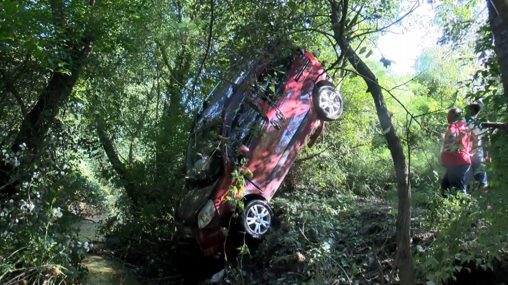 Dereye düşen otomobilden burunları bile kanamadan çıktılar