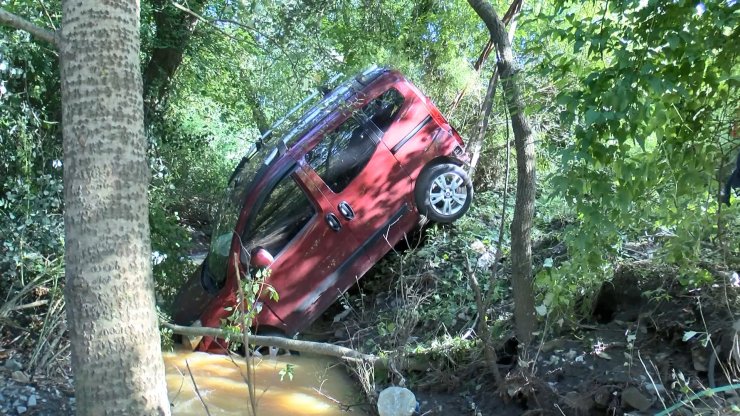 Dereye düşen otomobilden burunları bile kanamadan çıktılar