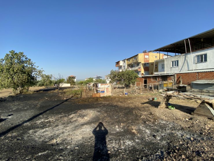 Anız yangınında alevler bahçesine sıçrayınca hortumla müdahale etti