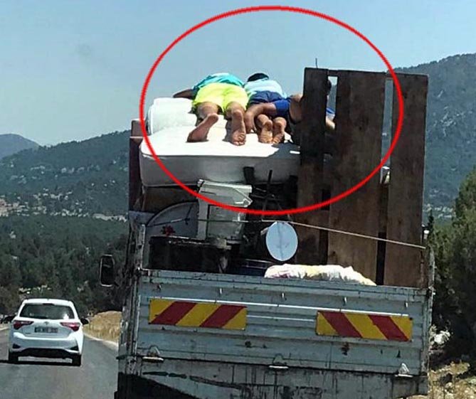 Eşya yüklü kamyonetin kasasındaki yatakta tehlikeli yolculuk