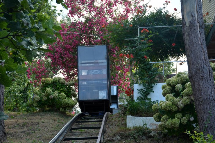 Tepedeki evine 30 metrelik raylı sistemle inip çıkıyor