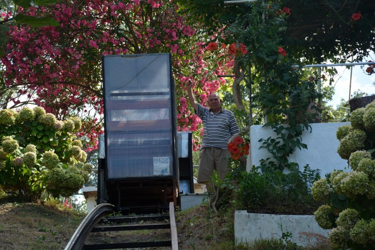 Tepedeki evine 30 metrelik raylı sistemle inip çıkıyor