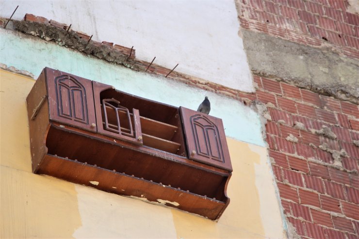 Bina duvarında asılı kalan dolap, ilgi odağı oldu