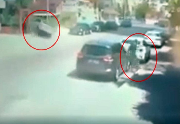 Savrulan otomobilden çocuğu da çekerek saniyelerle kurtuldu