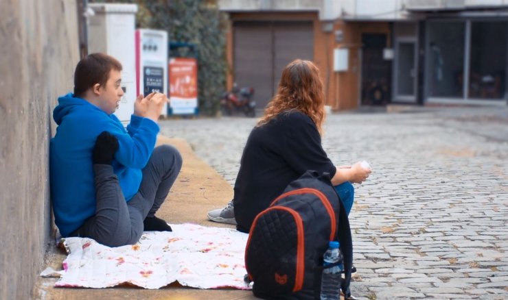 Kaldırımda oturarak servis bekleyen Eren'e özel durak