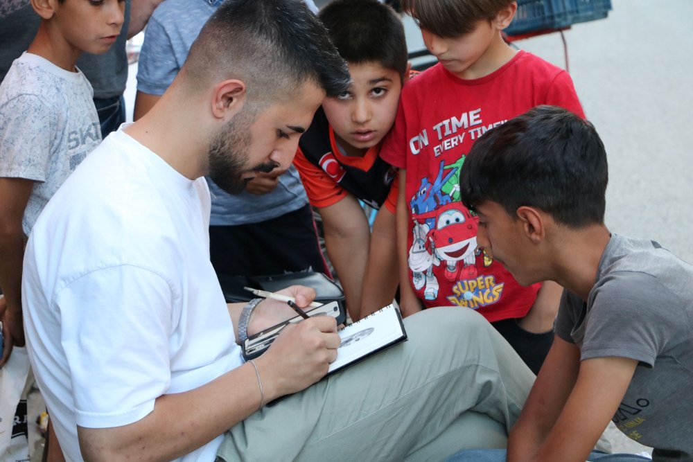 Tanımadığı kişilerin resmini çiziyor, hediye ederken video çekip sosyal medyada paylaşıyor