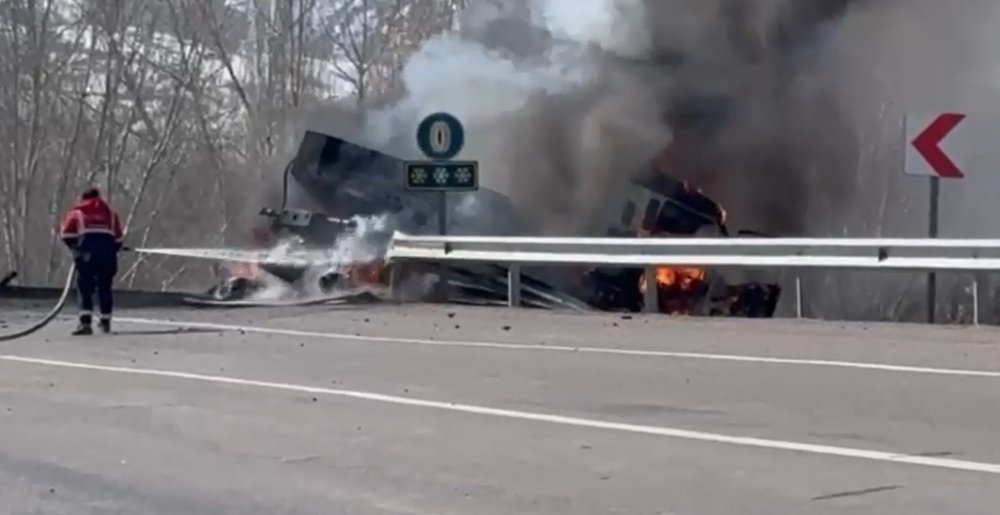 TIR devrildi, üzerindeki iş makinesi alev aldı; 3 yaralı